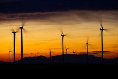 Wind turbines with a sunset in the background.