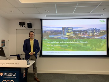 Prof. Martijn Heck standing in front of his presentation title slide