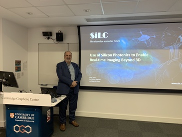 Man standing in front of a lecture screen next to a lectern.