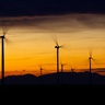 Wind turbines with a sunset in the background.