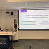 Lady standing in front of her presentation title slide.