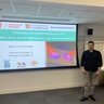 Man standing in front of a lecture screen next to a lectern.